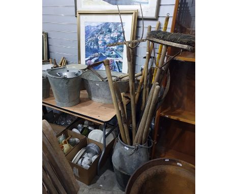 Galvanised milk churn and bath containing a selection of vintage tools, including rakes, hoes, spades, shearers, etc 