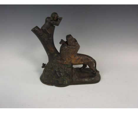 A 19th Century cast Money Box with monkey seated on tree trunk feeding a lion 9in H