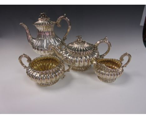 A George IV silver Tea and Coffee Service of circular fluted form with leafage scroll handles, the teapot and coffee pot with