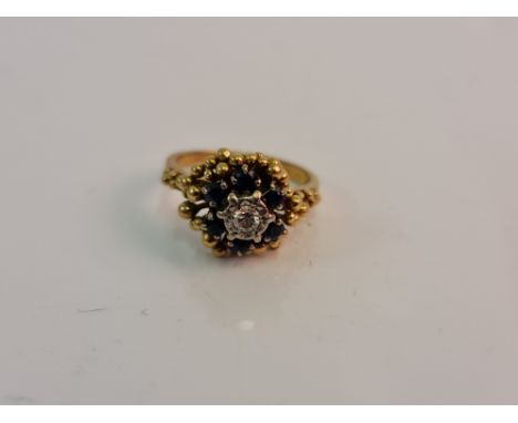A sapphire and diamond tiered cluster ring, with surrounding sphere metalwork design, diamond weight approx. 0.10ct, unmarked