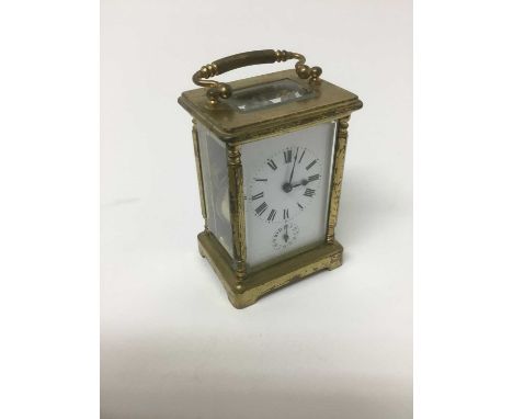 Early 20th century brass carriage clock with subsidiary alarm dial, surmounting swing handle, total height 15cm