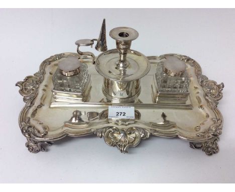 Late Victorian silver plated double inkstand with cut glass bottles and central taper stick with snuffer, foliate scroll bord