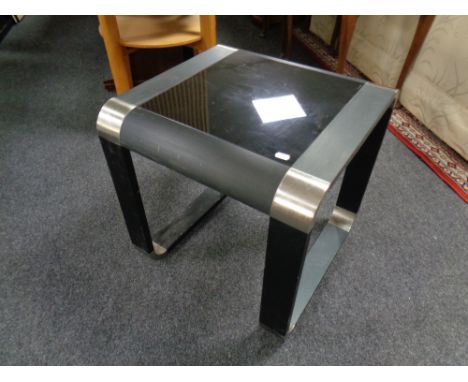 A contemporary lamp table with black glass inset panel 