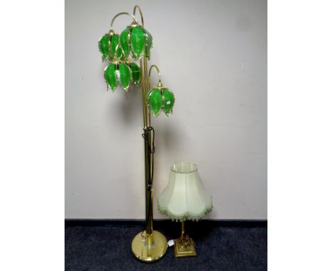 A contemporary brass five way floor lamp with green glass shades together with a brass Corinthian column table lamp with gree