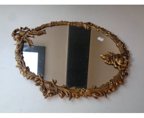 A decorative gilt metal framed mirror together with two cut glass lidded trinket pots and two cut glass candlestick holders  