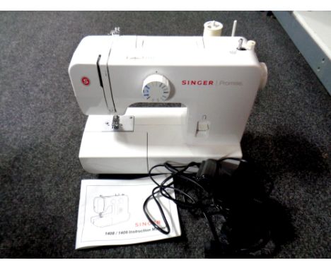 A Singer Promise electric sewing machine with foot pedal and manual