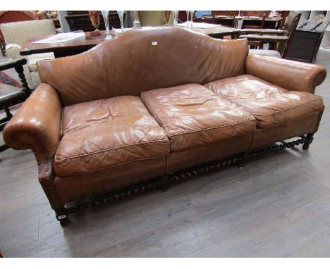 A three seater club leather sofa, worn, with barley twist stretcher, 213cm long