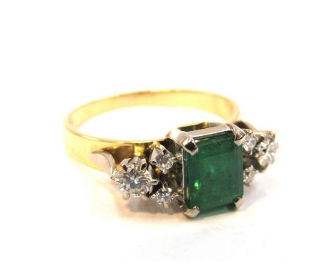 An enamelled and diamond ring, the central emerald 7mm x 5mm flanked by diamonds, stamped 750, size Q/R, 4.6g