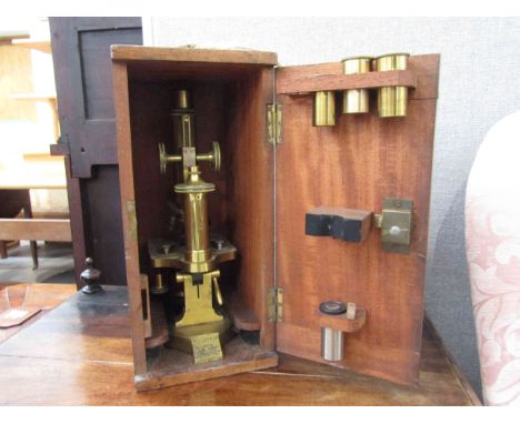 A Beck of London brass microscope with various obverse lenses, fitted case