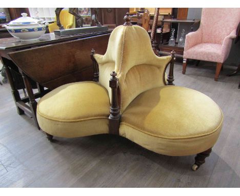 A Victorian mahogany conversation chair with carved finial and legs to ceramic castors