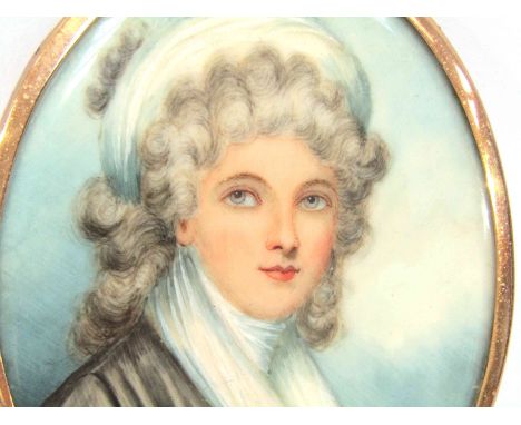 An early 19th Century oval miniature on ivory, portrait of a woman. Unsigned. Set in a yellow metal frame. Rear glass cracked