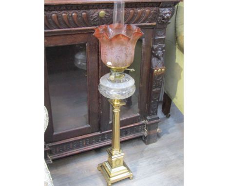 A Victorian brass oil lamp with frilled shade, brass column to pedestal base, 90cm tall