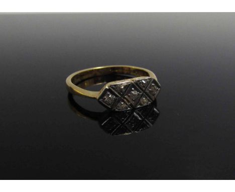 A gold ring in Art Nouveau design of seven diamonds in platinum set crisscross diamond patterned design, stamped 18k. Size R,