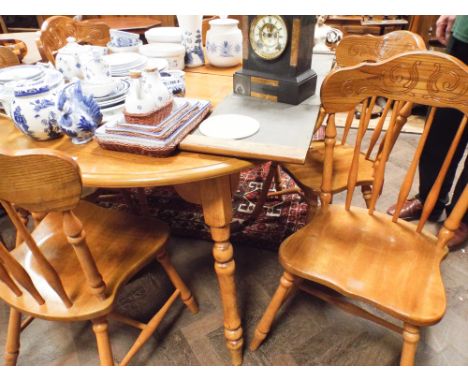 Circular oak extending dining table with 2 centre leaves and a set of 6 stick back dining room chairs with wooden panel seats