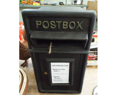 A wall mounted black post box with bracket