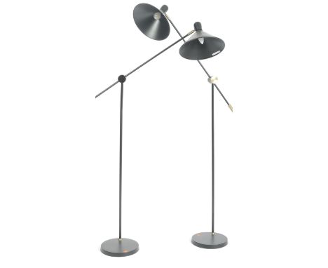 A pair of contemporary floor standing lamp lights having a black conical shade supported by single adjustable arms upon furth