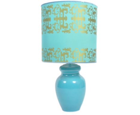 A large retro 20th Century blue glazed lamp light having a large blue and gold barrel shade upon a bulbous ceramic blue glaze