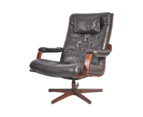 A retro mid 20th century Danish inspired swivel armchair / lounge chair having brown leather upholstery with cushioned button