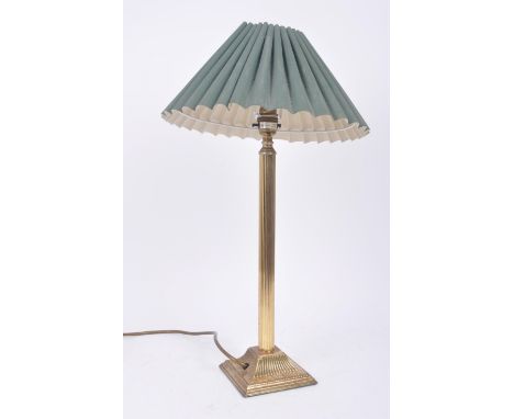 A vintage 20th century 1980s Hollywood Regency brass table lamp light having a green shade over a single reeded column. Raise