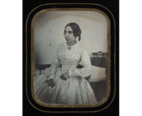 *Russian Ethnic Woman. Half-plate daguerreotype of a seated young woman in long dress, 1849,  brooch highlighted in gilt, sta