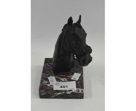 A metal model of a horses head on rectangular onyx base