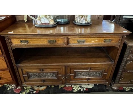 A late Victorian light oak serving sideboard or buffet with two drawers and two panelled doors with carved decoration, 137cm 