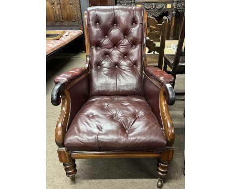 A Victorian rosewood and oxblood leather button back gents library type armchair with scrolled arm ends and turned legs with 