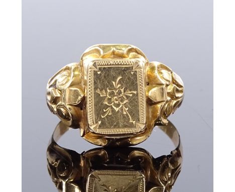 A Victorian unmarked gold signet ring, floral engraved central panel with relief scrolled shoulders, panel height 14.3mm, siz