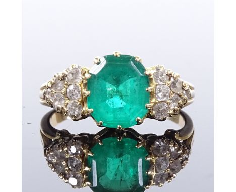 An early 20th century unmarked gold solitaire emerald ring, diamond cluster shoulders, total diamond content approx 0.5ct, oc