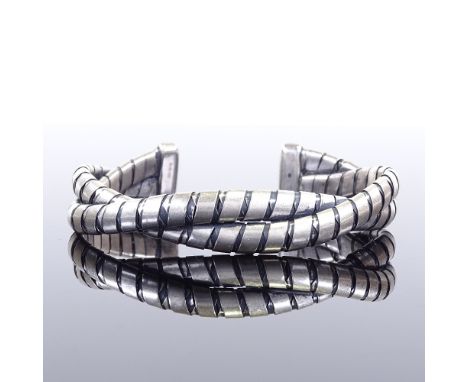 An Emporio Armani sterling silver torque bangle, interwoven design, internal width 7.2cm, internal height 6cm, 52.3gGood over