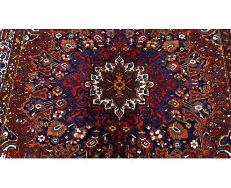 A large handmade Caucasian red and blue ground geometric design rug, 4.45m x 3.33m (14'7" x 10'11")Good condition with good s