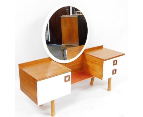 A mid century teak and white laminate dressing table, with a circular mirrored back above a narrow glass shelf and pink metal