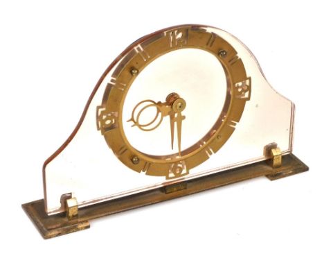 An Art Deco pink glass fronted mantel clock, with a circular brass dial bearing Arabic numerals at quarters, stylised hands, 