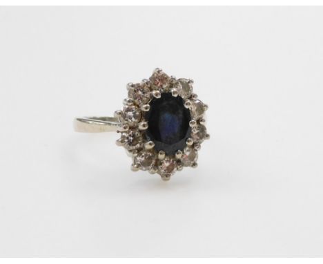 An 18ct white gold sapphire and diamond ring, the oval cut sapphire in a surround of diamonds, diamonds approx ⅔?ct, size L/M