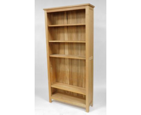 A light oak open bookcase of four shelves, raised on square supports, 201cm high, 96cm wide, 31cm deep.