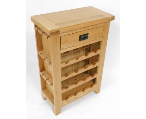 A light oak wine rack, with a frieze drawer, over sixteen bottle recesses, raised on stiles, 90cm high, 62cm wide, 32cm deep.