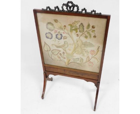 A late Victorian mahogany framed fire screen, with a carved bow surmount, rectangular glazed front with silk work tapestry of