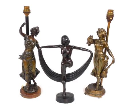 An early 20thC spelter figure of a nude dancing woman, 29cm wide, and a near pair of cold painted spelter figural table lamps