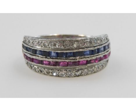 A diamond, ruby, and sapphire half hoop eternity ring, set with a band of baguette cut rubies, and sapphires, flanked by two 