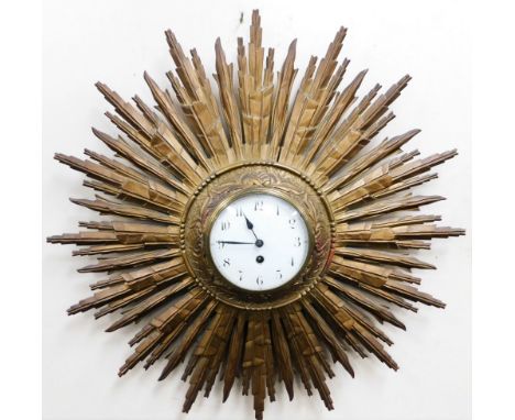 An early 20thC French starburst wall clock, the circular white enamel dial bearing Arabic numerals, thirty hour movement, 64c