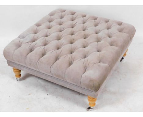 A Belfast Furniture Limited lounge stool, upholstered in grey button back draylon, raised on turned beech legs, capped on cas