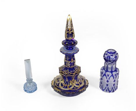 Three Glass Scent-Bottles, comprising: a gilt-heightened blue glass example, 19.5cm high; a cased glass example and a small l