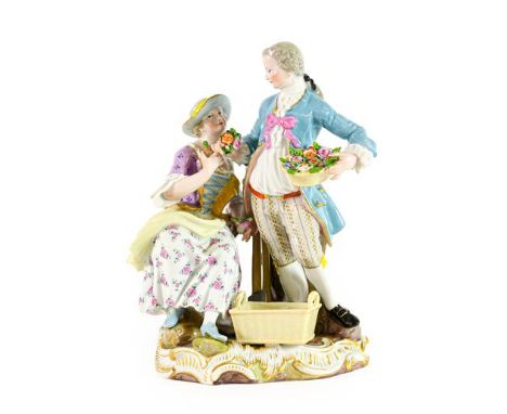 A Meissen Porcelain Figure Group, late 19th century, as a lady and gentleman in 18th century costume, he holding a basket of 