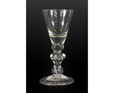 A Wine Glass, circa 1720, the conical bowl with solid base and basal knop on a angular baluster stem with air tear and folded