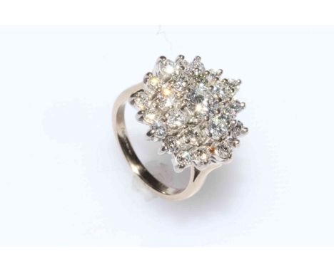 Impressive diamond cluster ring set in 18 carat gold, the tiered setting having centre diamond approximately 0.55 carat, SI, 