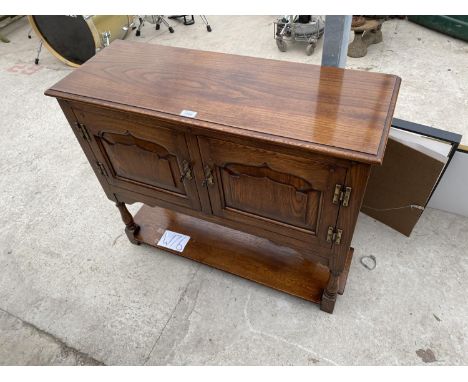 AN OAK SIDE CABINET WITH TWO DOORS AND LOWER SHELF 