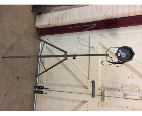 A grey industrial spot light on tripod base