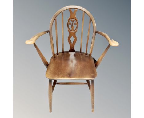 An Ercol elm and beech Fleur de Lys open armchair 