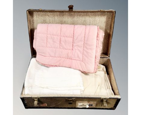 A vintage metal bound trunk containing assorted blankets 