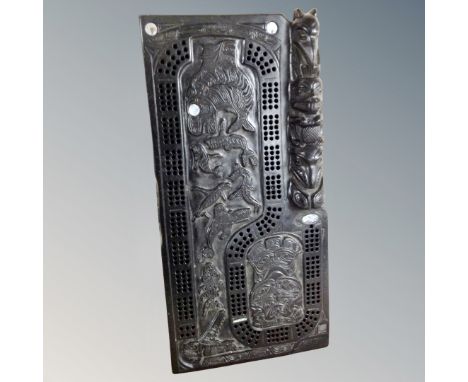 A Pearlite carved ebonised cribbage board 